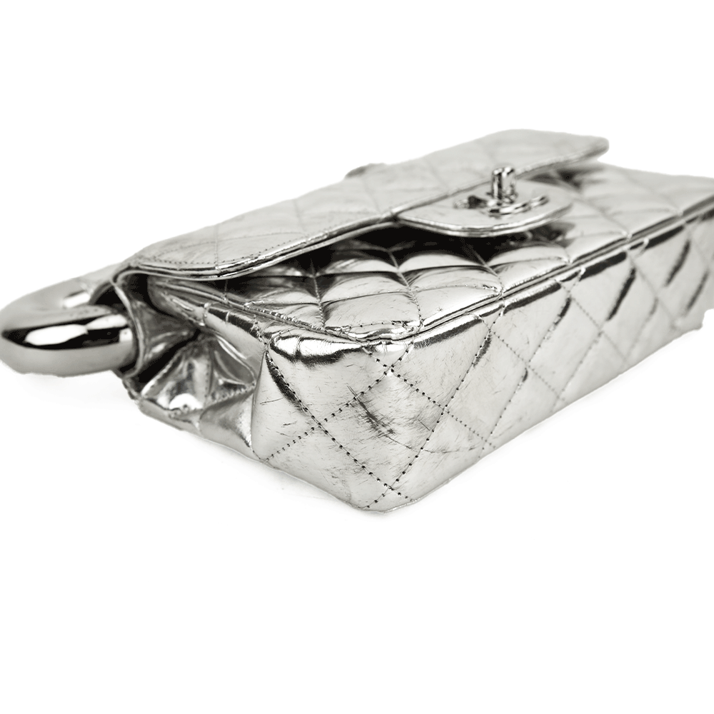 Corner view of Chanel Around The World Silver Quilted Clutch